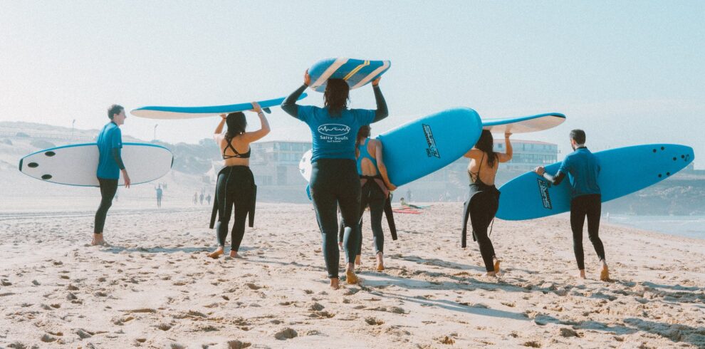 Group of People Carrying Surfboards